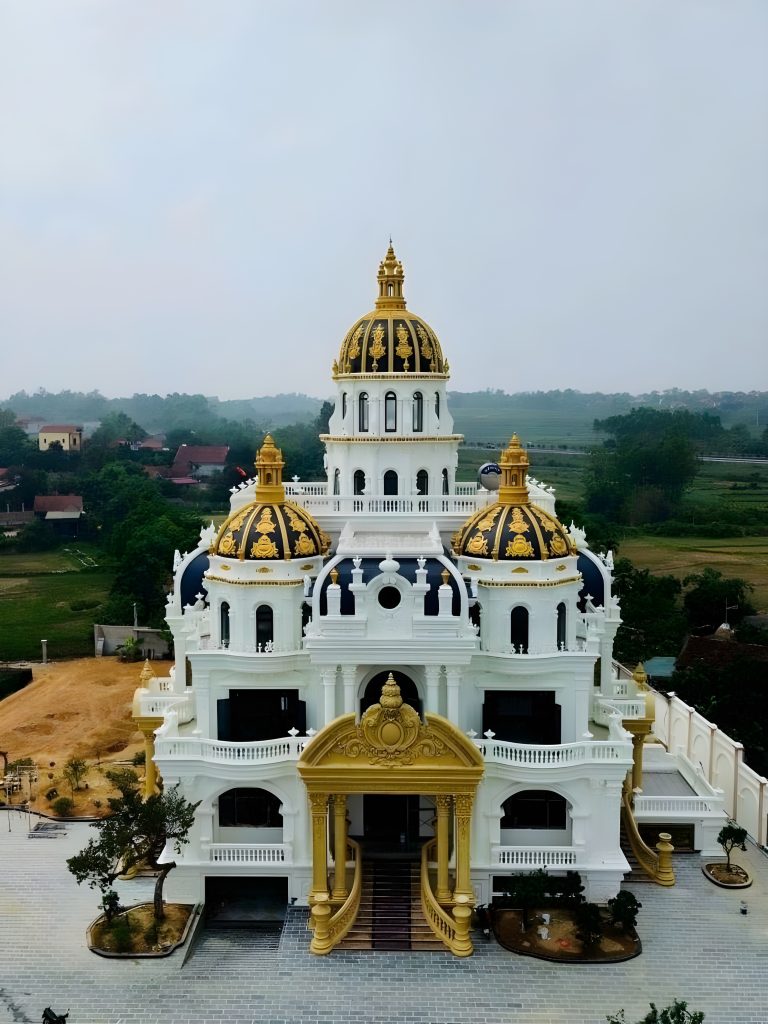 Biệt thự phong cách tân cổ điển với mái vòm lớn và họa tiết dát vàng được thiết kế bởi PT Kiến trúc Việt Nam, tọa lạc tại Thanh Hà, nổi bật với vẻ đẹp sang trọng và quy mô đẳng cấp.