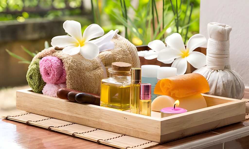 Một khay gỗ trưng bày sản phẩm spa bao gồm khăn, tinh dầu, xà phòng, và hoa tươi, thể hiện một trải nghiệm thư giãn và sang trọng, gợi mở một không gian khách sạn với thiết kế mùi hương đặc trưng.