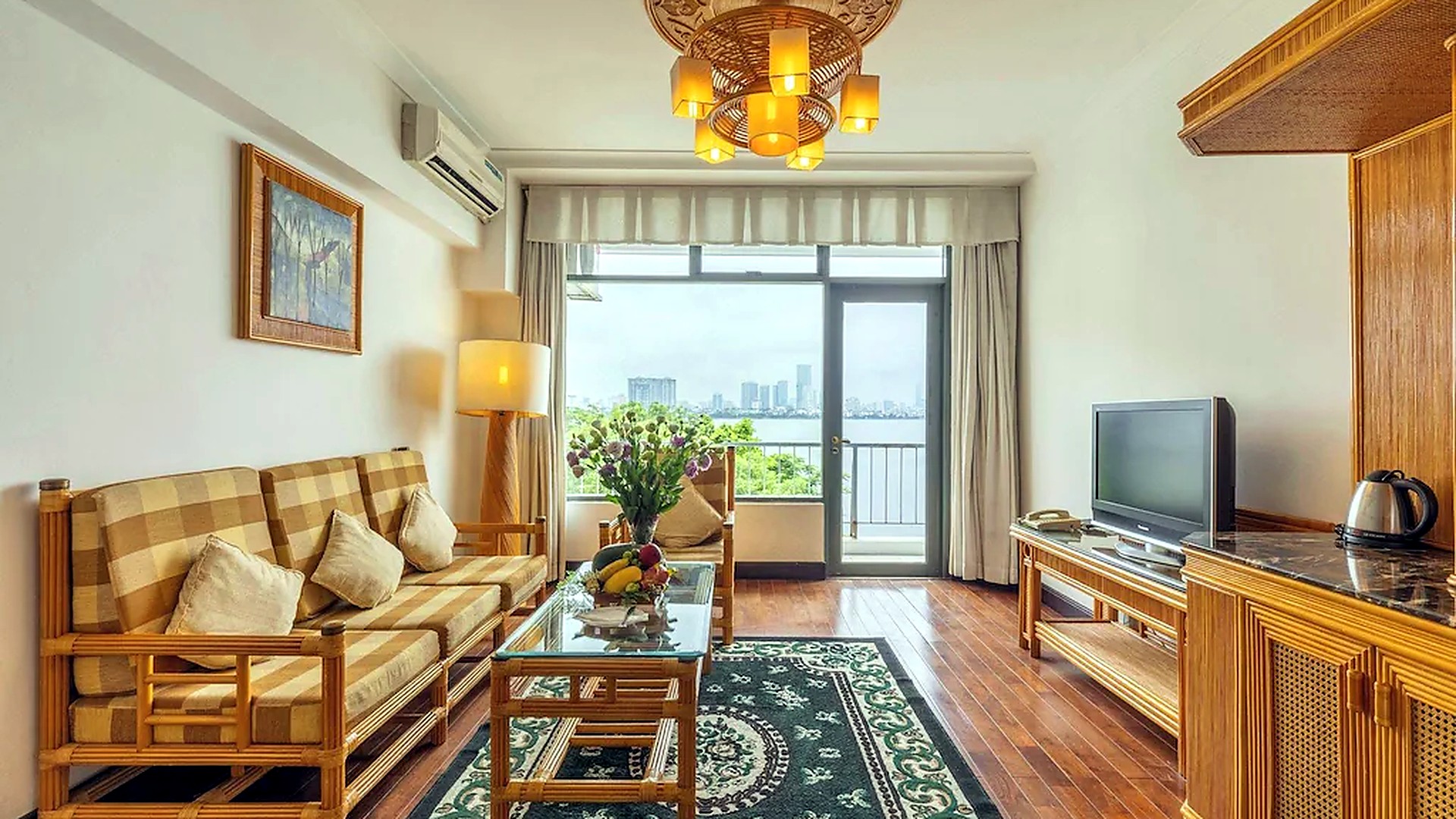 Phòng suite khách sạn 4 sao phong cách tân cổ điển có khu tiếp khách và view hồ.