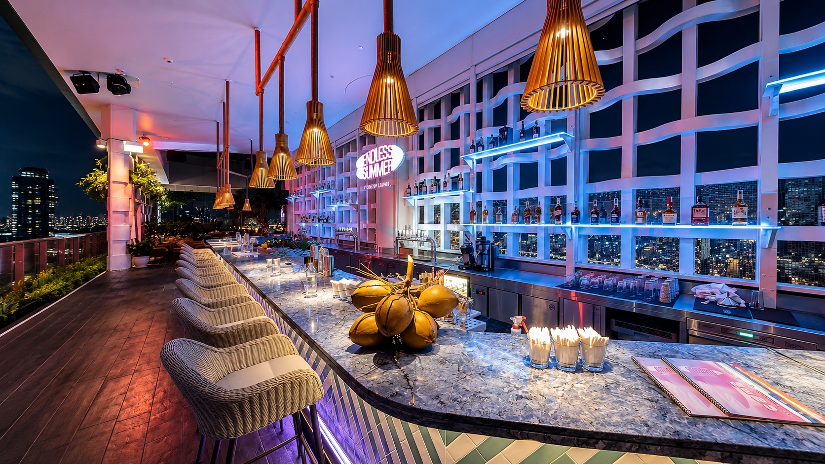 Quầy bar sân thượng của khách sạn 4 sao mang phong cách hiện đại, nổi bật với ánh sáng neon và tầm nhìn thành phố.