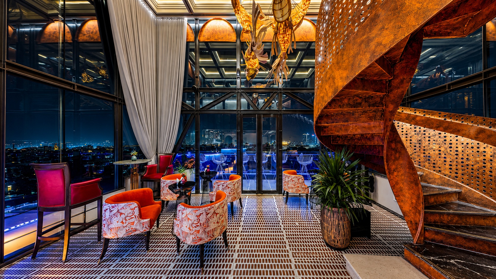Không gian lounge sang trọng với cầu thang nghệ thuật và tầm nhìn đêm thành phố, phù hợp cho trải nghiệm thư giãn và gặp gỡ.