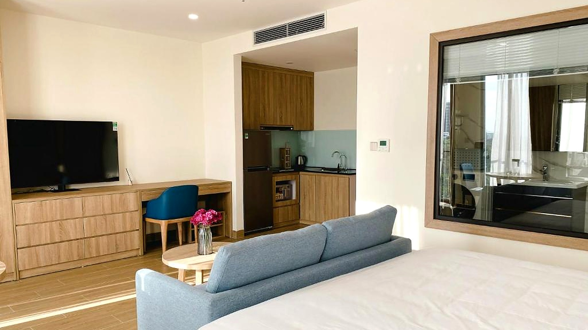 Phòng studio khách sạn 4 sao có giường, sofa, bàn làm việc và khu bếp nhỏ