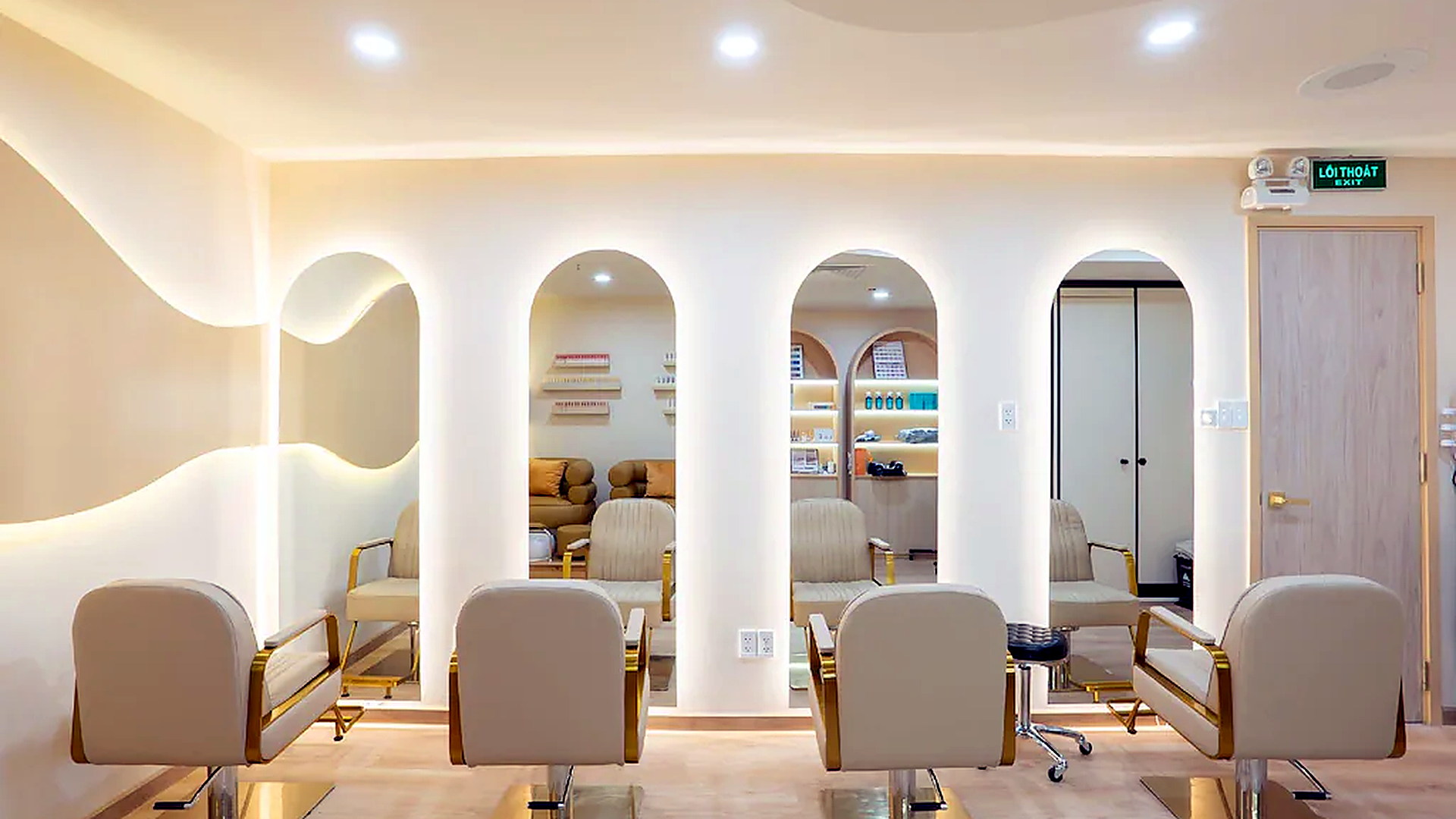 Khu salon làm đẹp có hệ gương lớn, ghế chuyên dụng và ánh sáng rõ ràng.