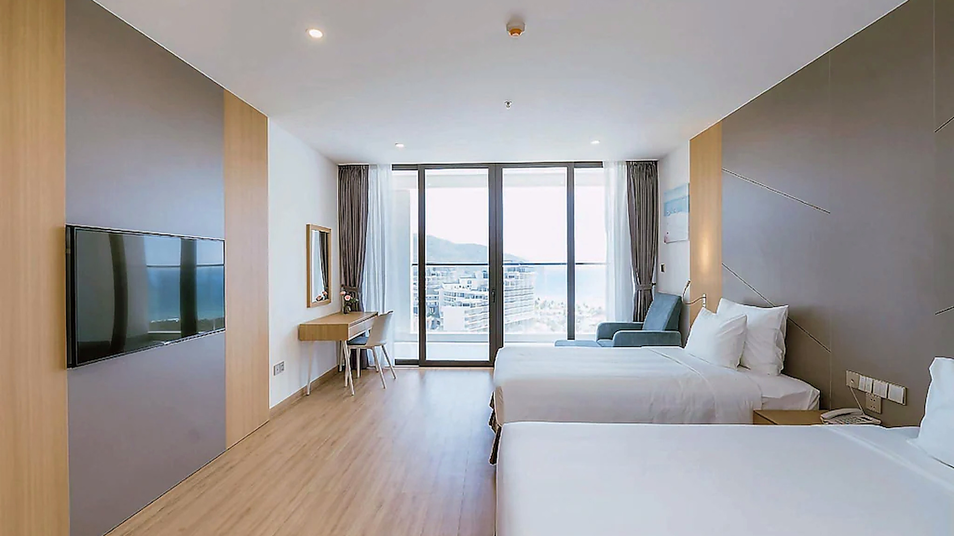 Phòng hai giường có cửa kính lớn, bố cục gọn gàng và tầm nhìn thoáng.