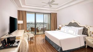 Phòng king khách sạn 4 sao với giường lớn, ban công và nội thất sang trọng.