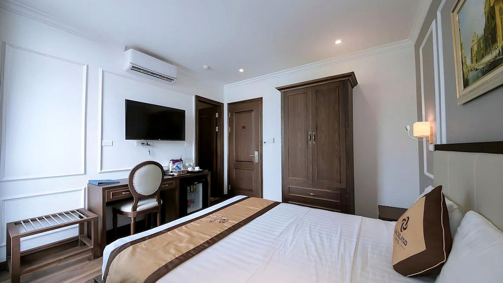 Hệ TV, bàn làm việc, tủ đồ và minibar được gom gọn để tăng tiện nghi mà không chiếm diện tích.