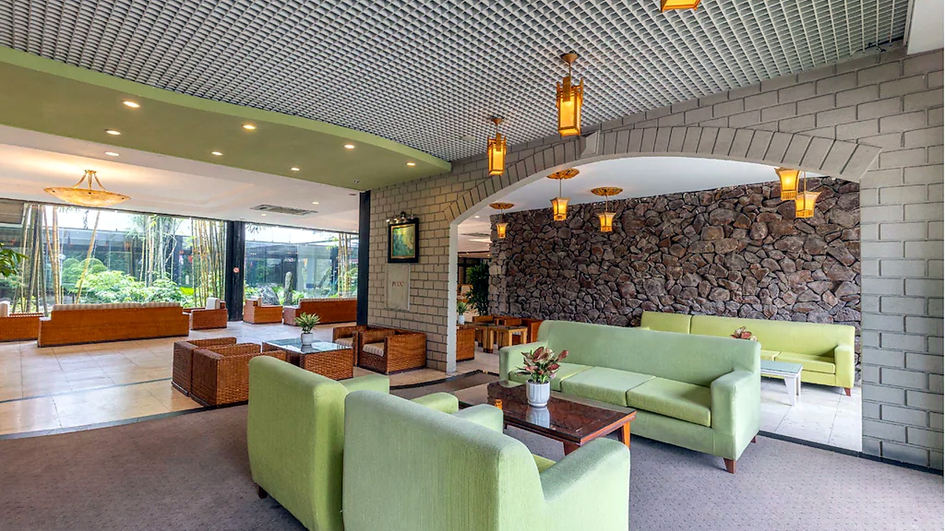 Khu lounge khách sạn 4 sao với sofa và mảng tường đá tạo cảm giác thư giãn.