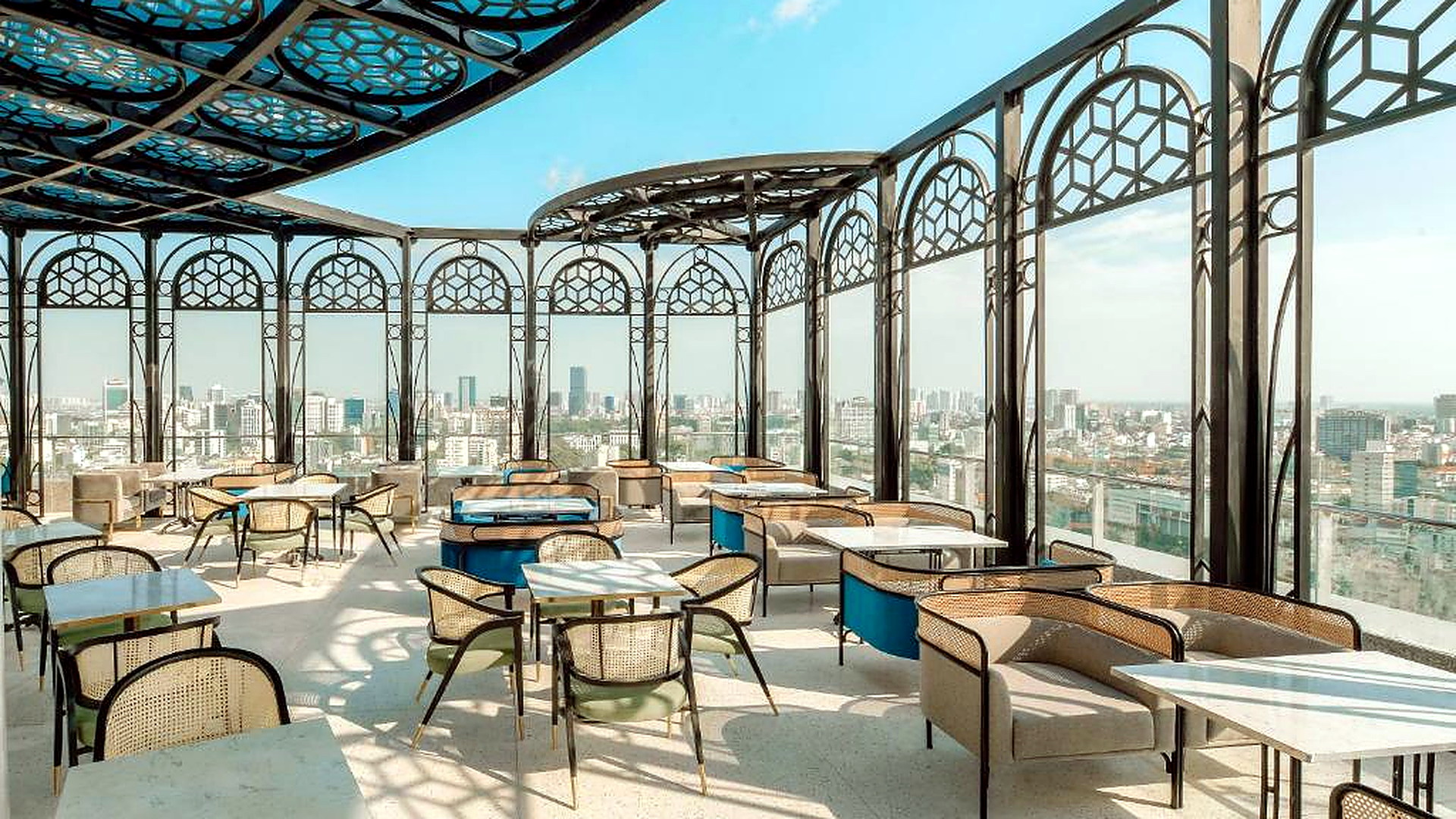 Rooftop lounge thoáng đãng, nhiều bàn ghế và tầm nhìn mở ra đường chân trời đô thị.