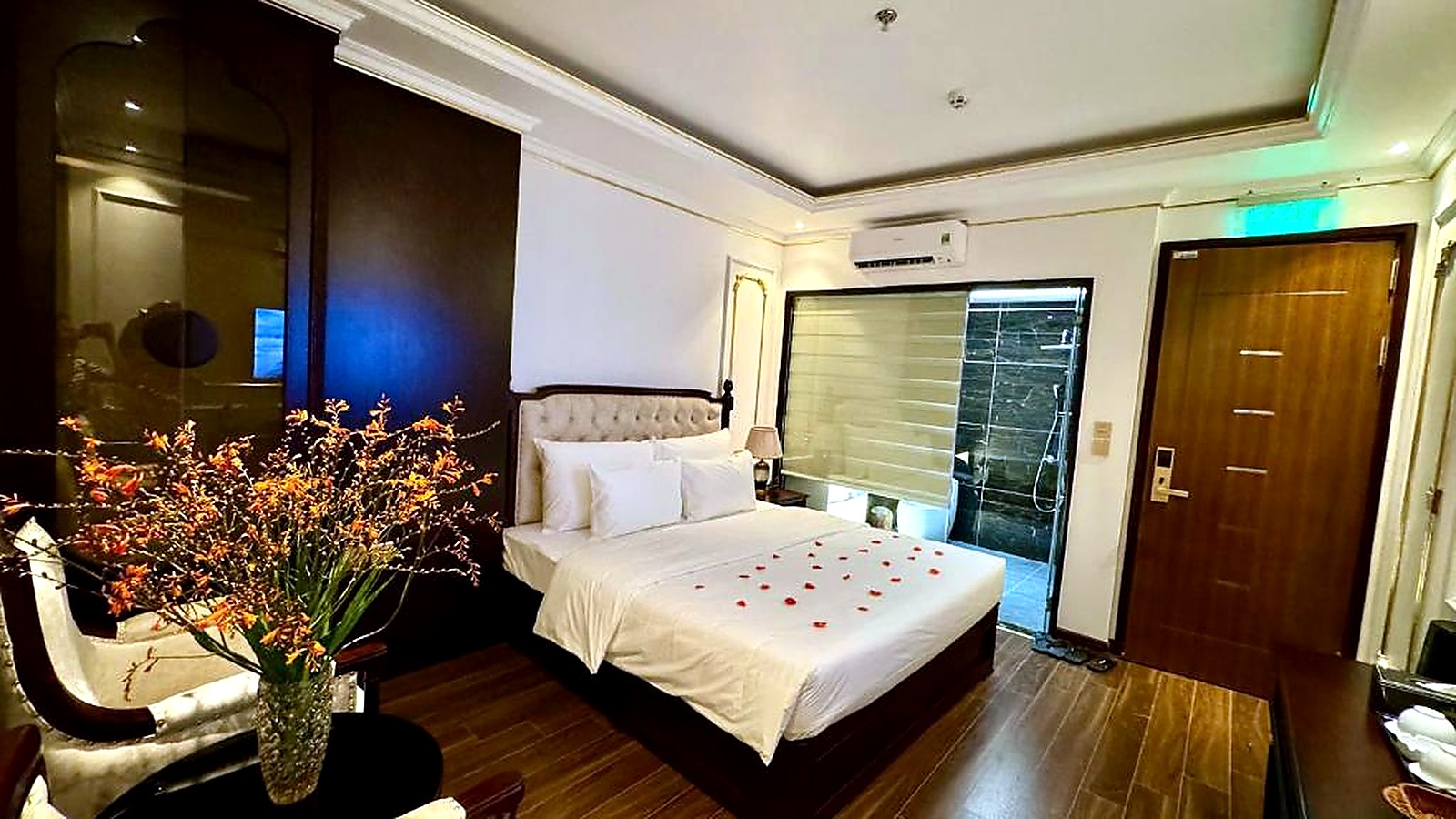 Phòng ngủ ấm áp với gỗ tối màu, ga trắng và chi tiết trang trí mang hơi hướng Đông Dương.