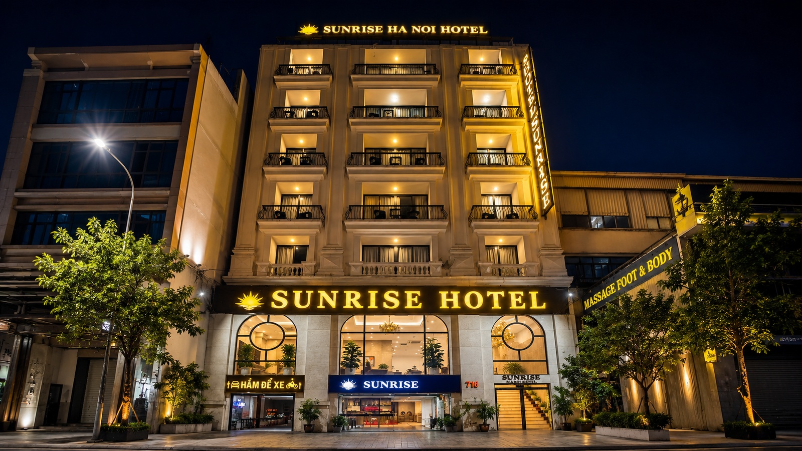 Ngoại thất khách sạn 3 sao Sunrise Hanoi Hotel nổi bật về đêm với hệ đèn vàng sang trọng và biển hiệu nhận diện rõ ràng.