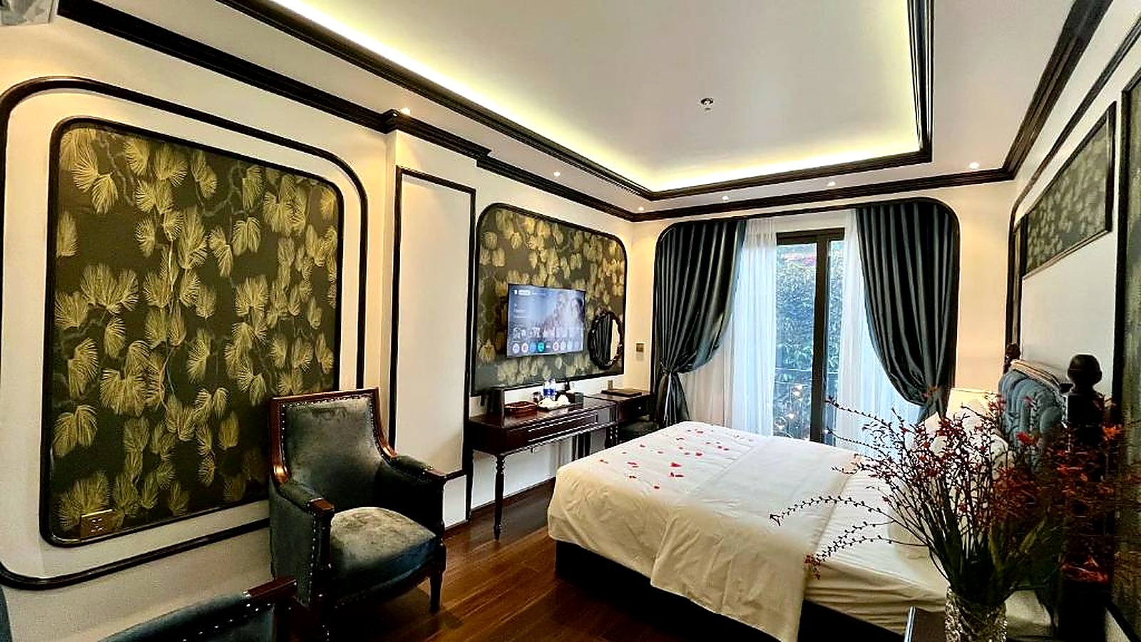 Họa tiết lá và ghế xanh làm không gian phòng có chiều sâu, giàu bản sắc.