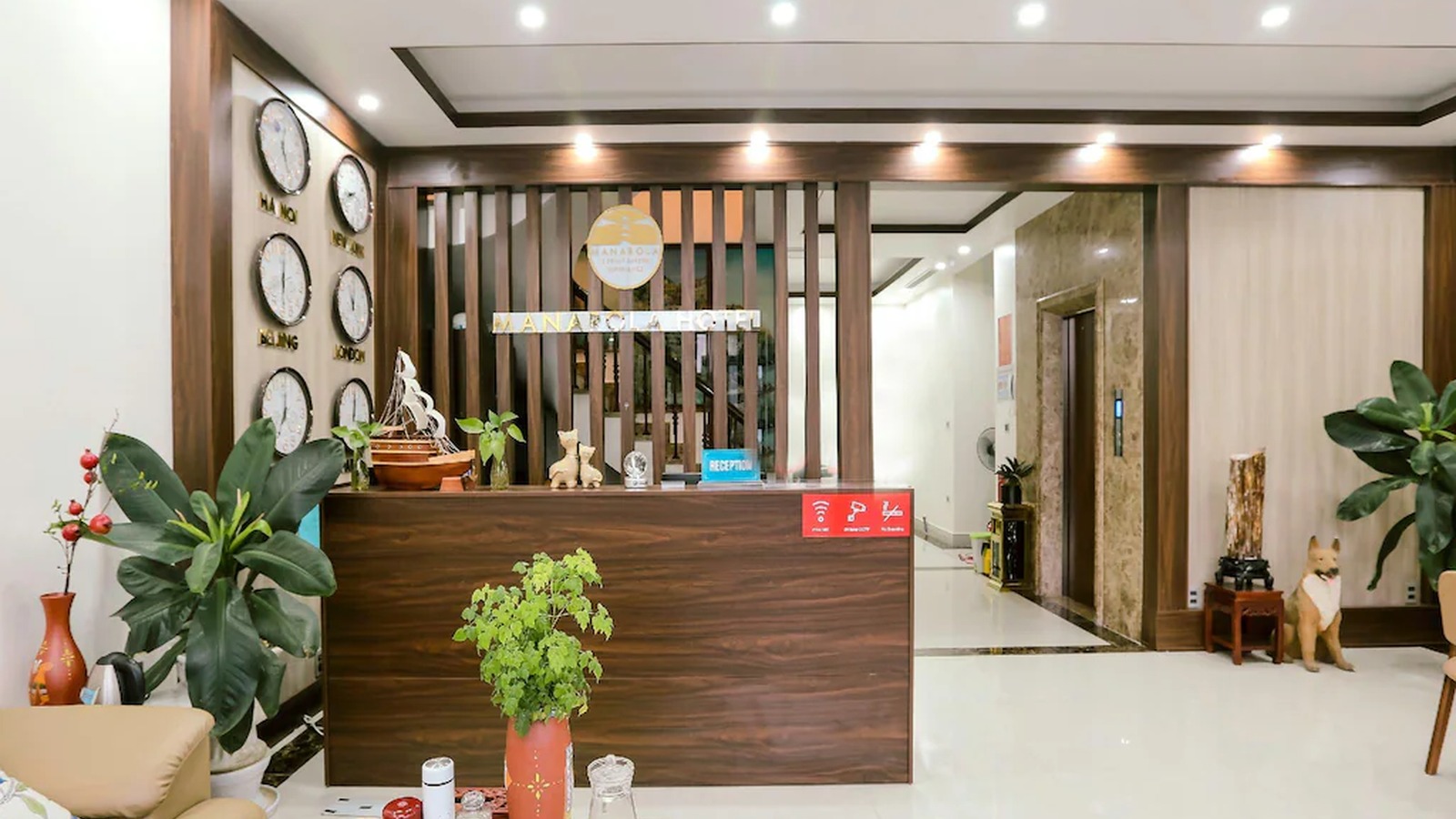 Sảnh lễ tân khách sạn 2 sao Manarola với quầy gỗ và cây xanh