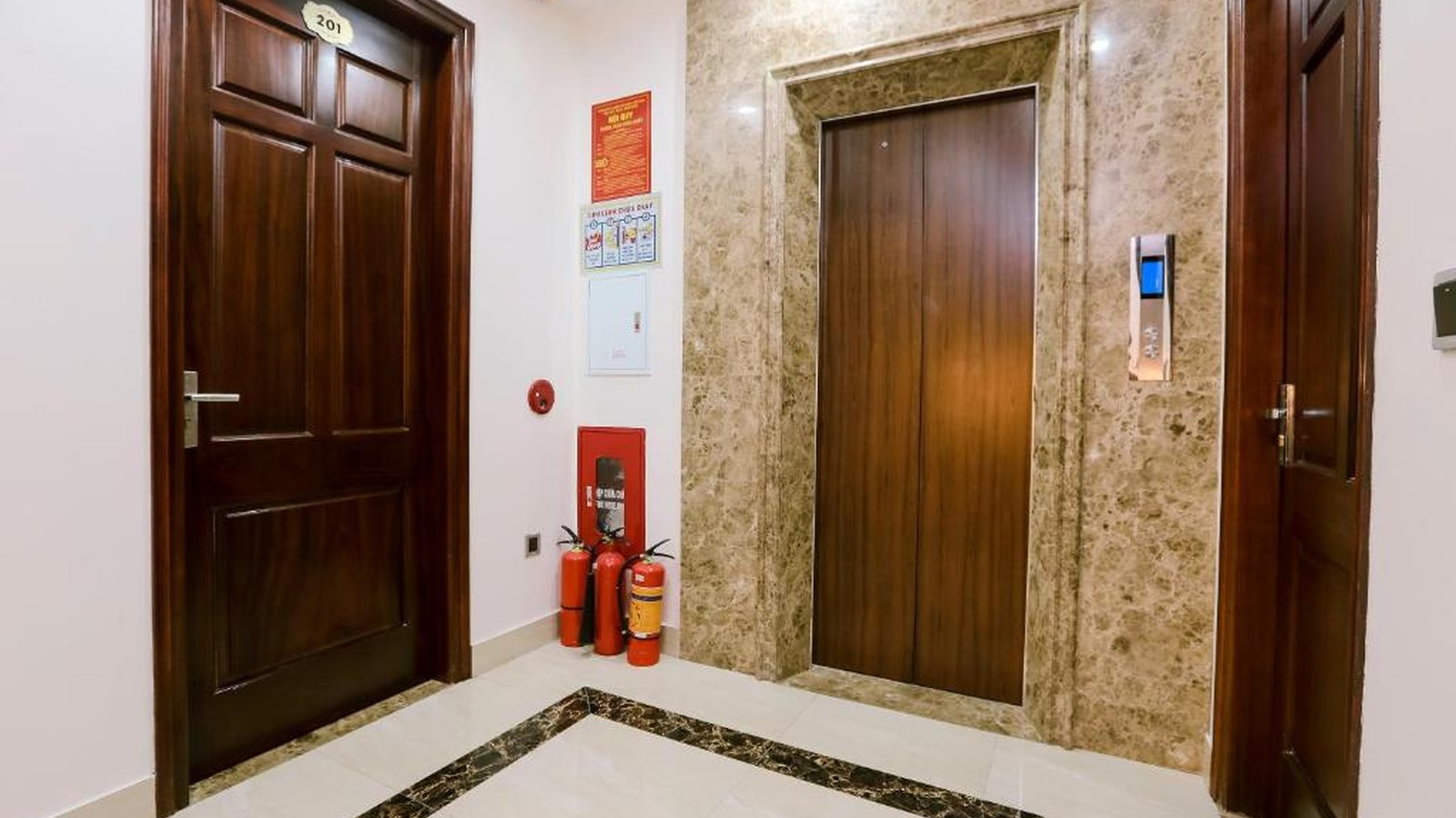 Khu vực thang máy khách sạn 2 sao với vật liệu đá và gỗ