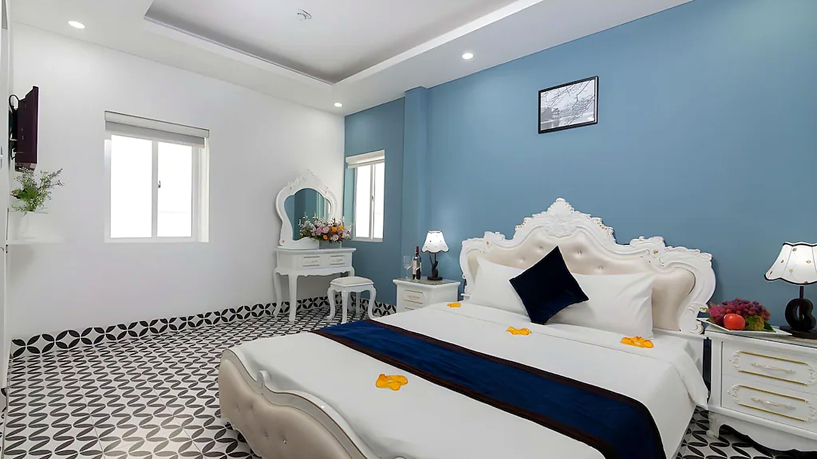Phòng giường đôi sử dụng nền xanh - trắng và nội thất đường cong tạo dấu ấn Indochine đương đại.