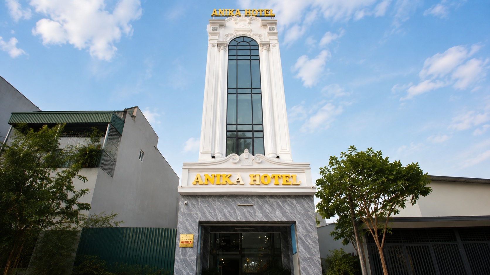 Mặt tiền khách sạn 2 sao tân cổ điển Anika Hotel với hệ kính lớn và bảng hiệu nổi bật.