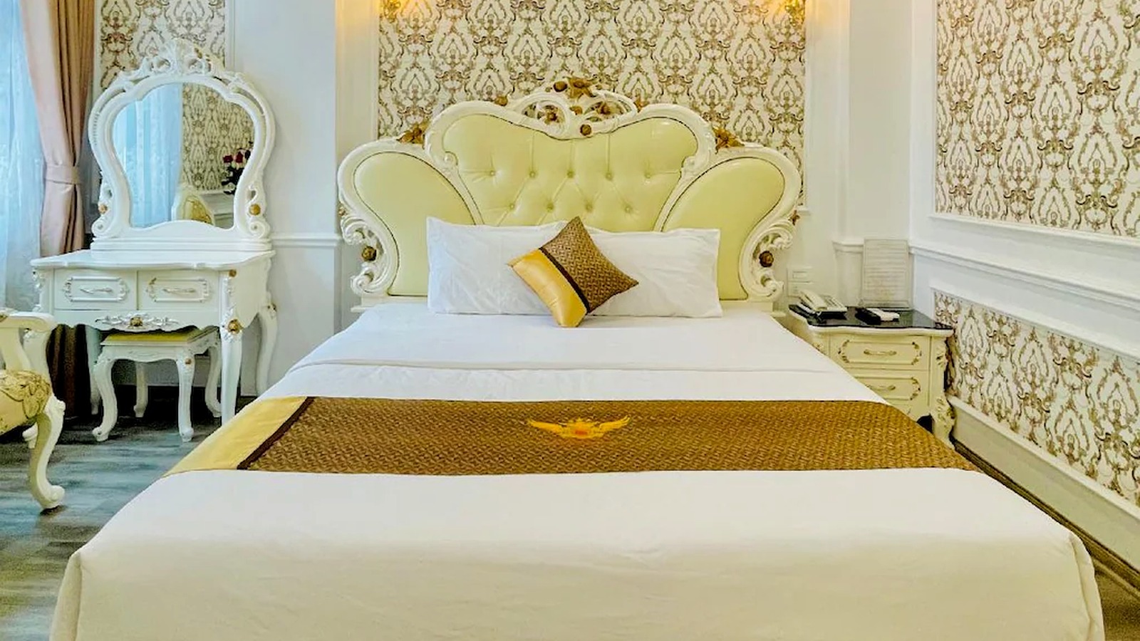 Phòng một giường đôi với đầu giường tạo hình mềm mại và nội thất đồng bộ.