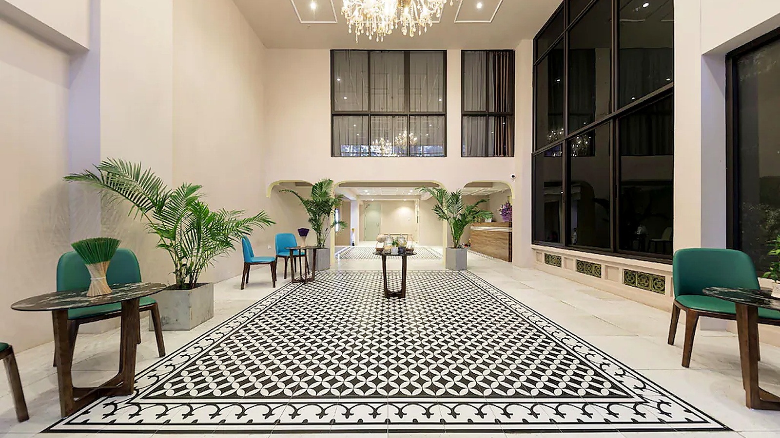 Sảnh lobby khách sạn 3 sao hiện đại sử dụng nền sáng, gạch họa tiết đen trắng và cây xanh để tạo điểm nhấn thị giác.