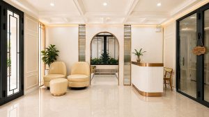 Thiết kế sảnh khách sạn 3 sao sử dụng bảng màu kem - trắng, quầy lễ tân bo cong và ánh sáng đồng đều.