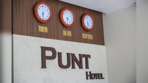 Lối vào Punt Hotel sử dụng kính lớn và bảng hiệu rõ ràng, phù hợp khách sạn mặt tiền phố.