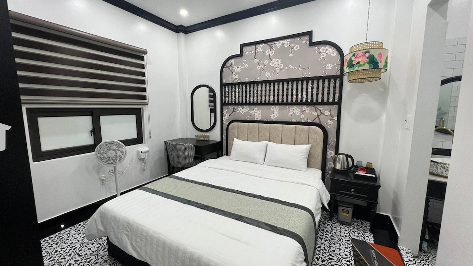 Phòng đôi khách sạn 2 sao Indochine với đầu giường hoa văn và nội thất tối màu