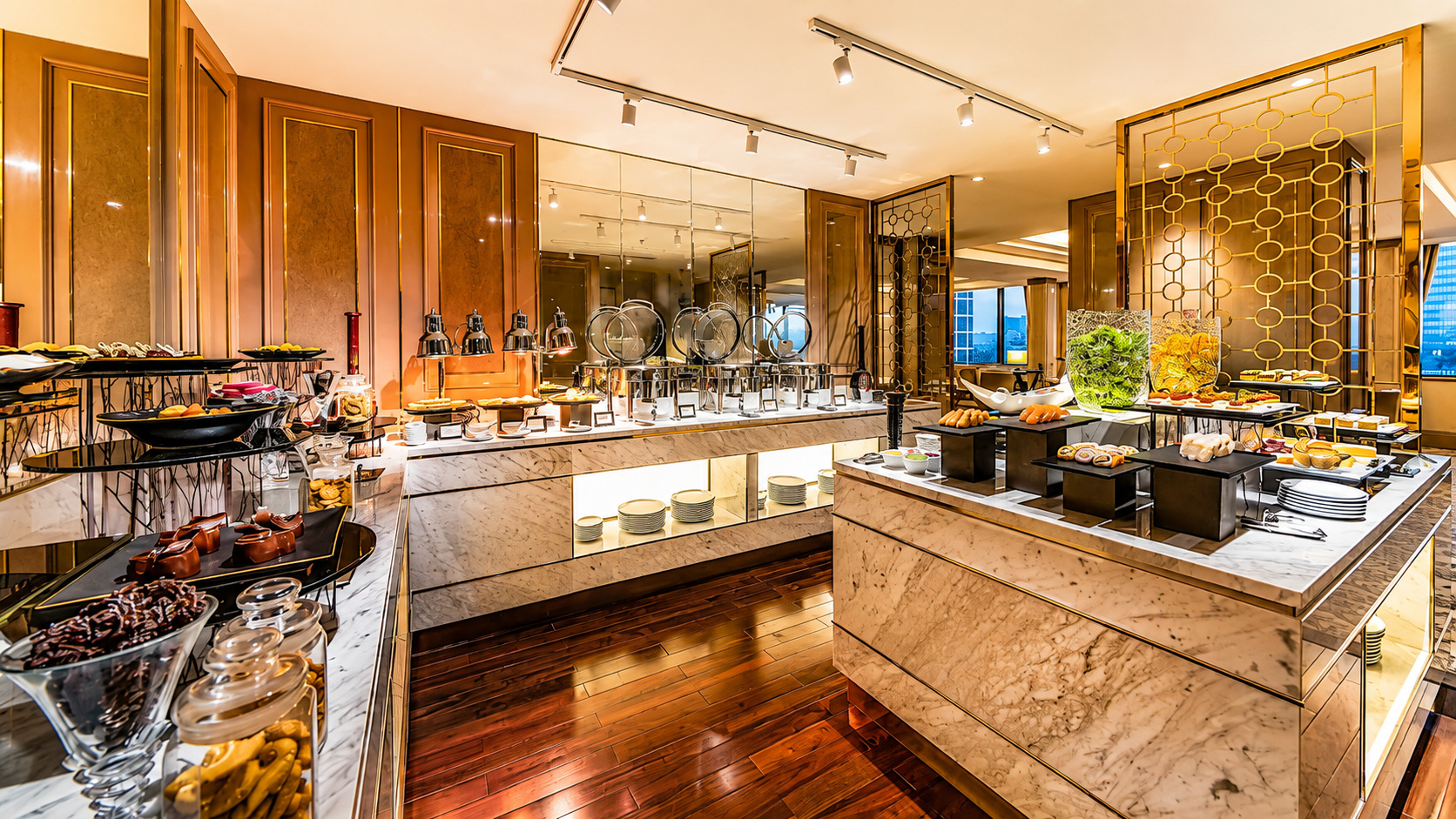 Khu buffet khách sạn 5 sao với quầy đá sang trọng, ánh sáng ấm và cách bày trí món ăn chỉn chu.
