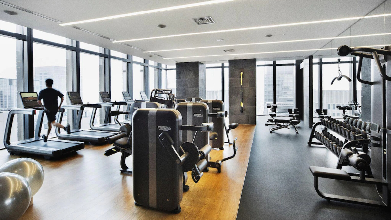 Phòng gym hiện đại sử dụng bảng màu gỗ và đá trung tính, giữ tinh thần Wabi Sabi trong một tiện ích năng động.