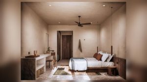 Phòng king tiết chế với tường vữa thủ công, giường thấp và những lớp gỗ nâu tạo cảm giác yên tĩnh