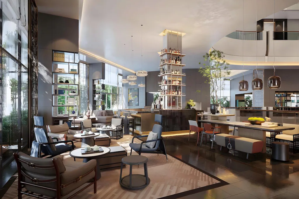 Lounge mở kết hợp quầy bar, cây xanh và nhiều cụm ghế cho các nhịp sử dụng khác nhau.