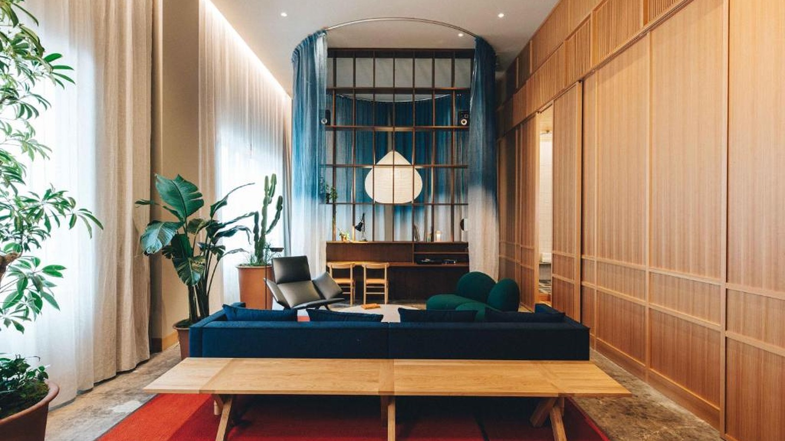 Gỗ sáng, rèm mềm, cây xanh và vài mảng màu sâu tạo lounge vừa tĩnh vừa có cá tính.