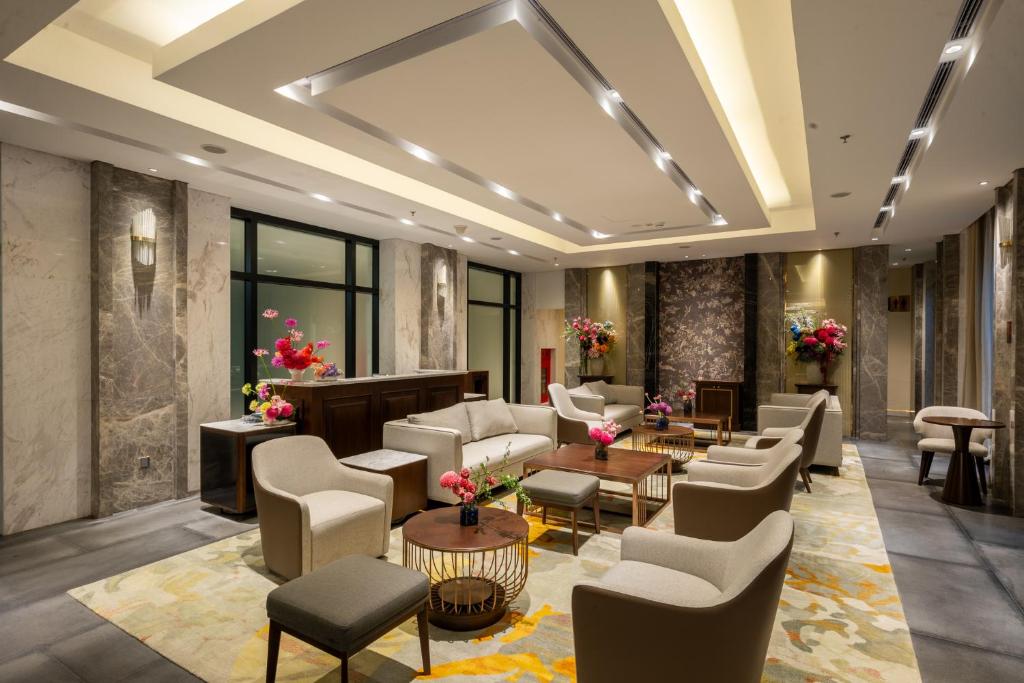 Sảnh chờ khách sạn 4 sao với đá sáng, ghế bọc vải và đèn trần hình học