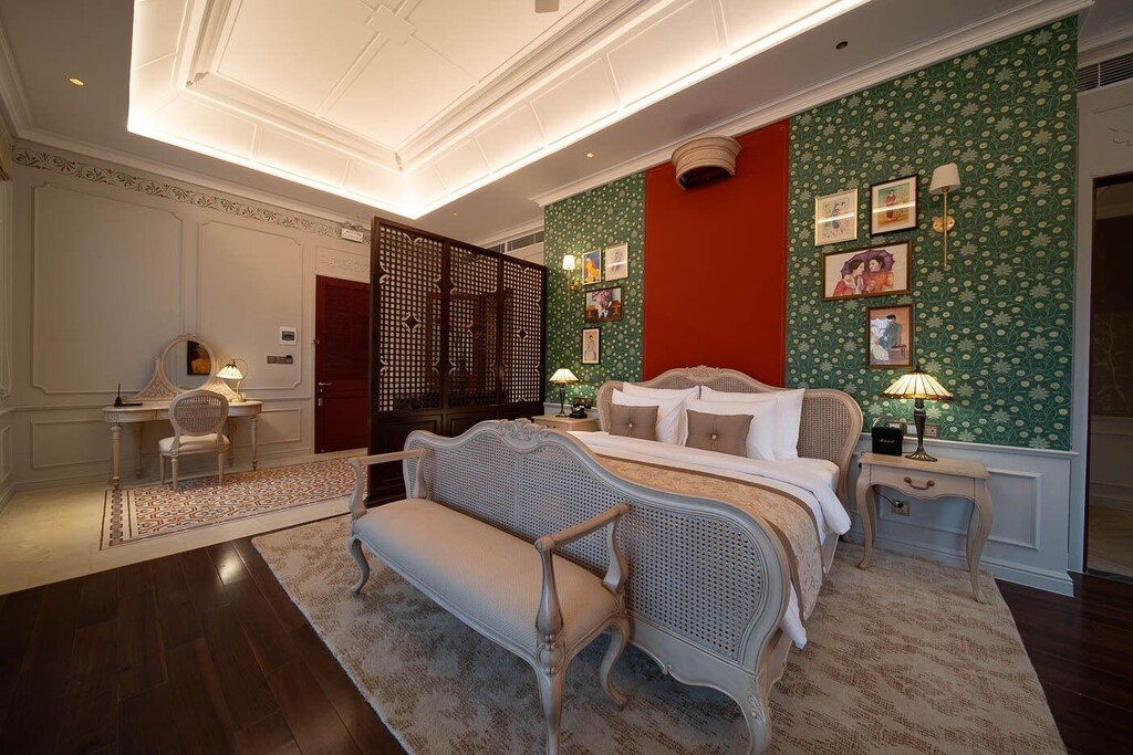 Suite diễn giải di sản bằng các mảng xanh, đỏ, hoa văn nhỏ và đồ gỗ trong một bố cục sáng, tiện nghi.