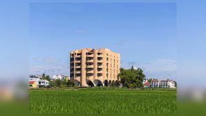 Khối nhà màu đất với các hốc cong nổi bật giữa thảm lúa xanh nhưng vẫn giữ quan hệ trực tiếp với địa hình thấp và rộng
