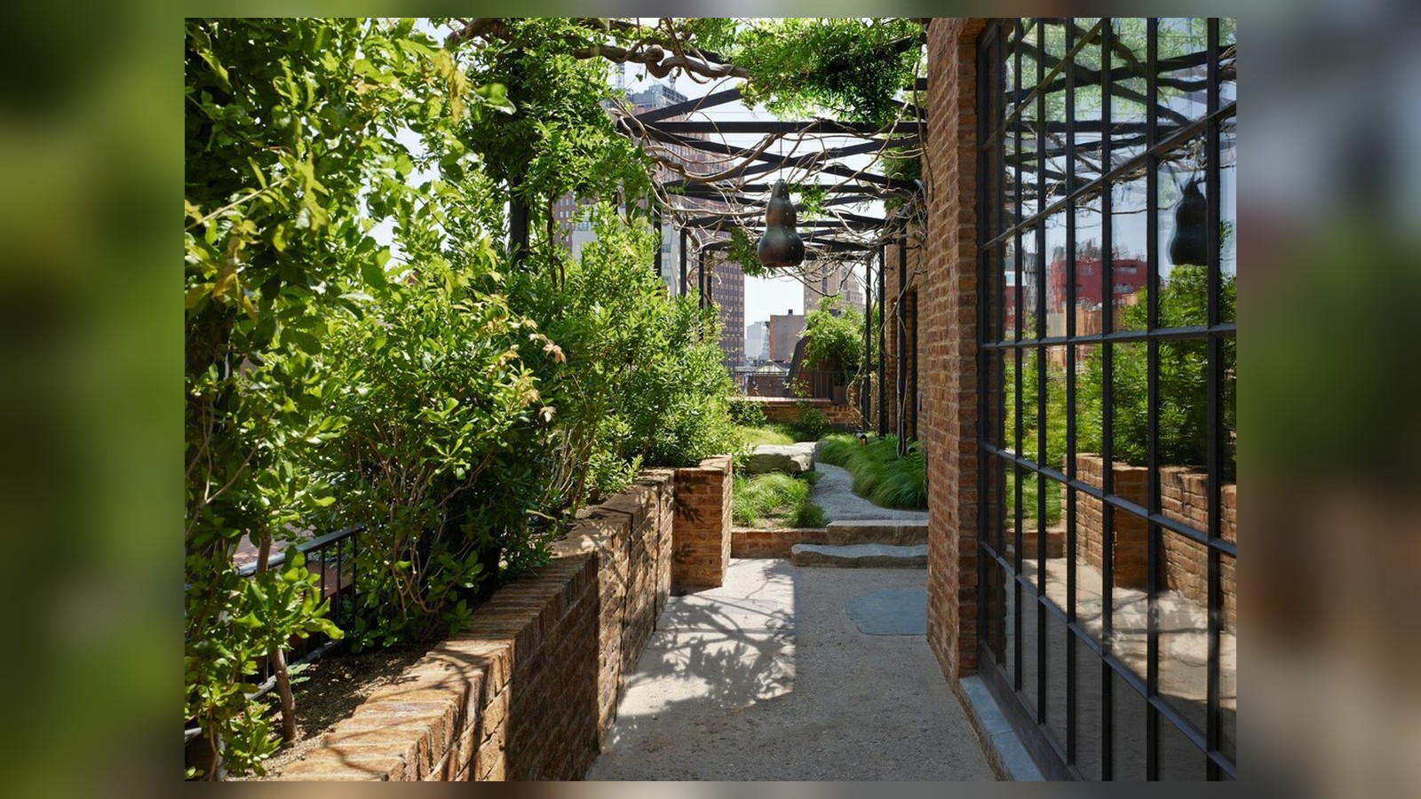 Lối đi hẹp giữa cây xanh và bề mặt đá biến quãng chuyển tiếp thành một trải nghiệm chậm rãi.