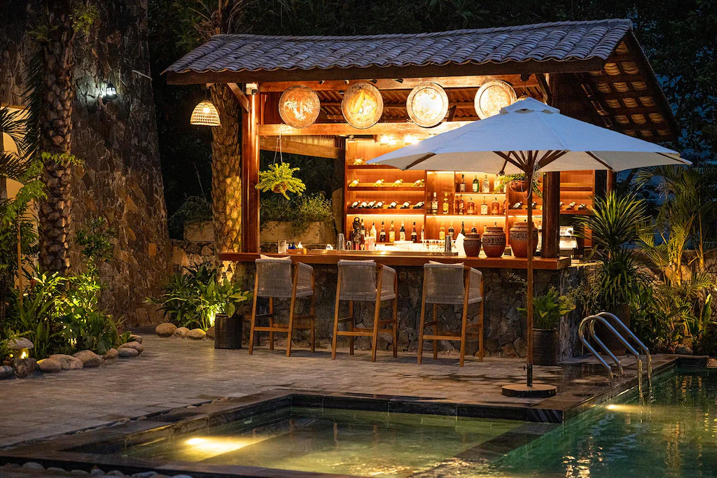 Quầy bar nhỏ bằng gỗ đá và mái ngói kết nối trực tiếp với mặt nước.