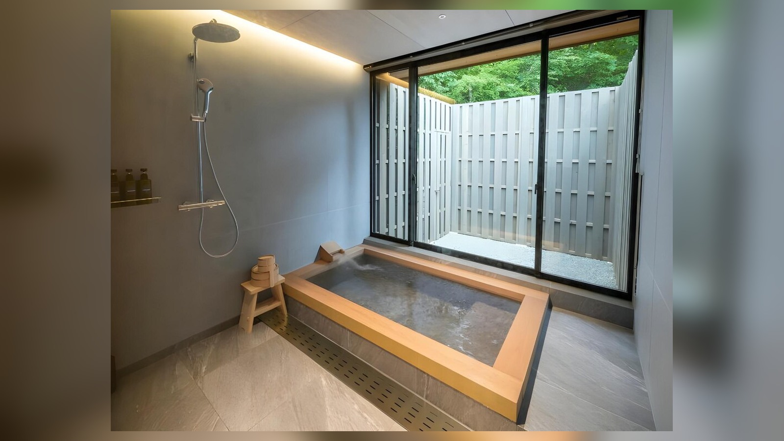 Bồn ngâm trong nhà đón ánh sáng và màu xanh qua cửa kính nhưng vẫn giữ sự riêng tư.