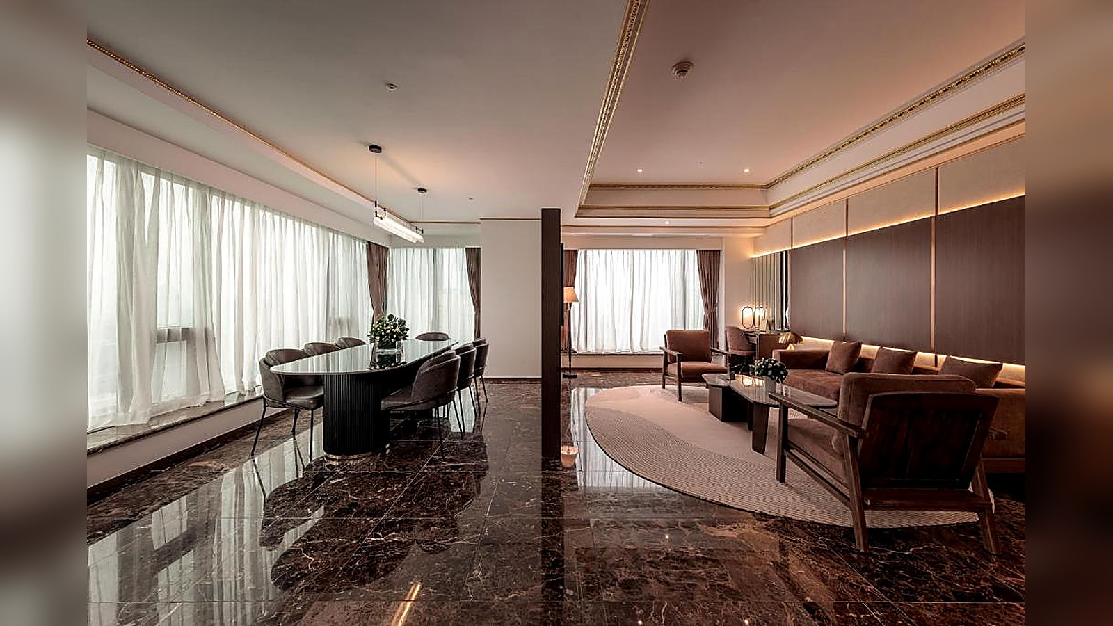 Suite cao cấp có khu tiếp khách, bàn ăn nhỏ và tầm nhìn rộng, phù hợp khách lưu trú dài ngày