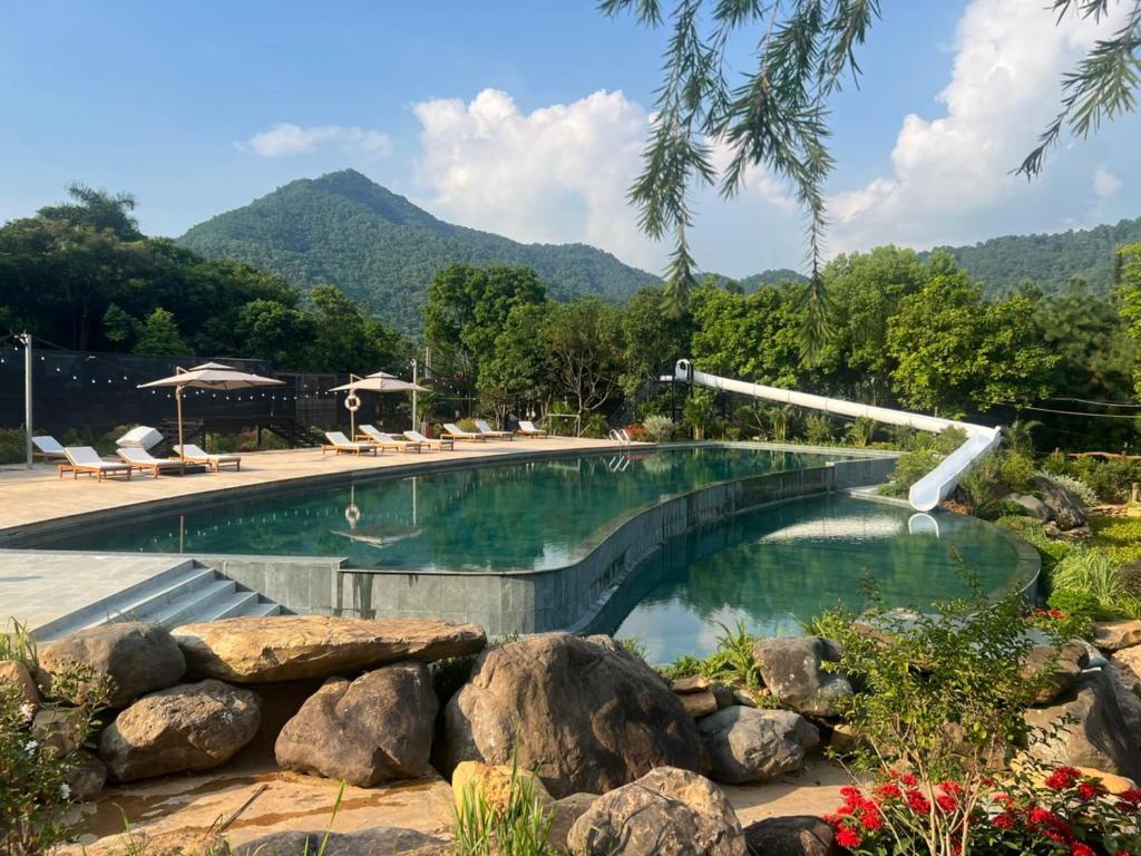 Hồ bơi cong, ô che, ghế nằm và máng trượt tạo tiện ích thư giãn cho cả người lớn lẫn trẻ em.