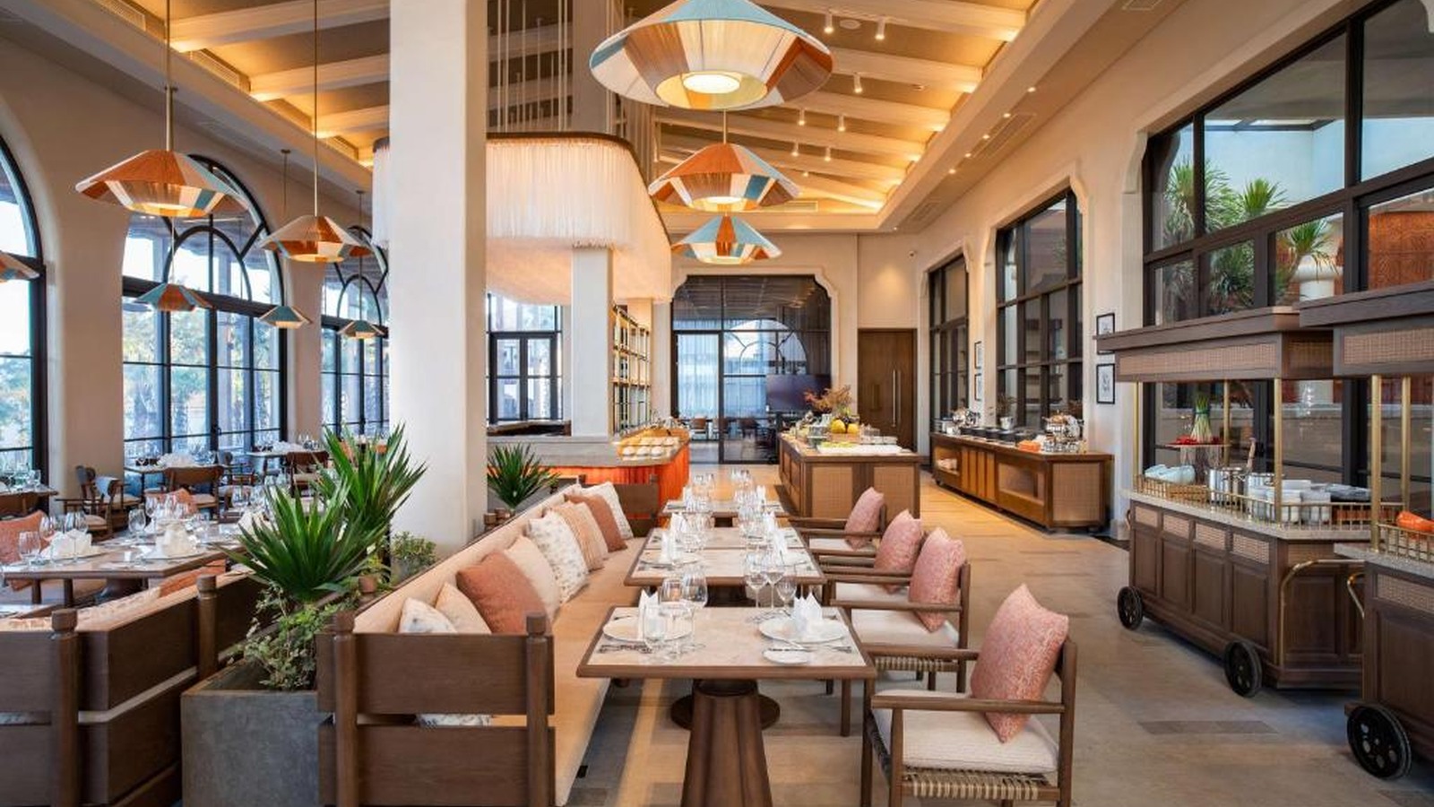 Nhà hàng buffet có mái dốc, đèn mây và lối phục vụ rộng, sáng, dễ quan sát.
