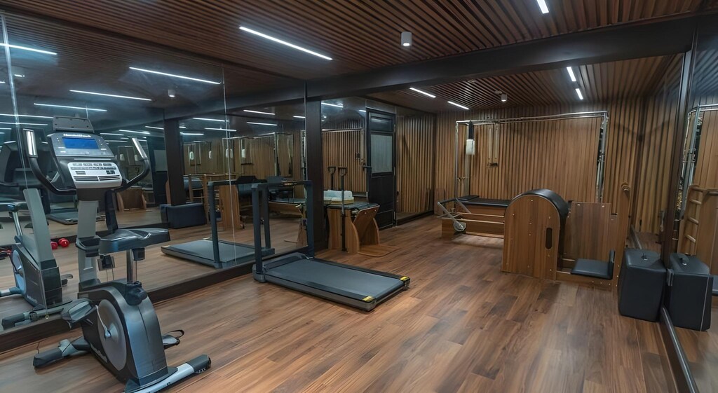 Sàn gỗ, gương lớn và hệ máy tập được bố trí thành một phòng gym gọn, phục vụ vận động hằng ngày.