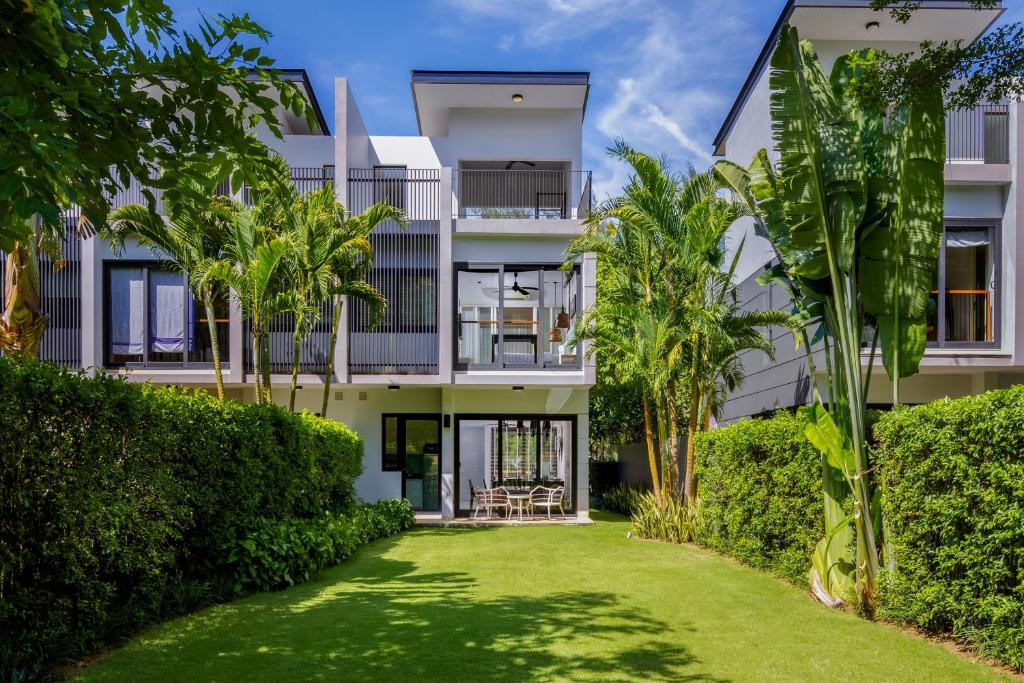 Khối nhà trắng, mái bằng, lam đứng và cây cao tạo hình ảnh hiện đại nhưng thích nghi với khí hậu nhiệt đới.