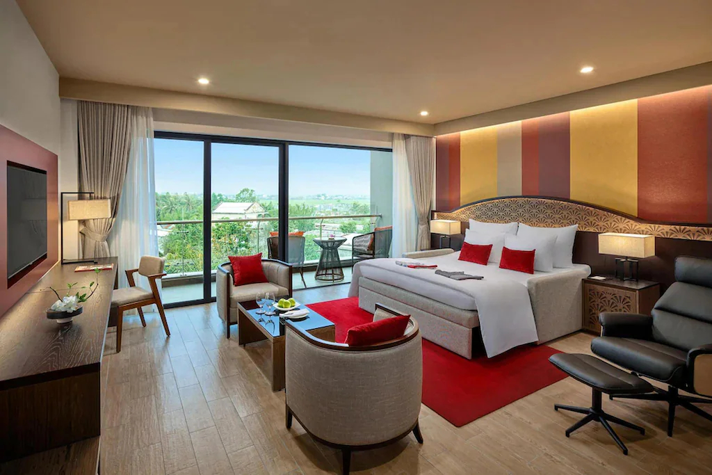 Suite kết hợp giường, lounge và ban công trong bảng màu gỗ, be cùng đỏ trầm.