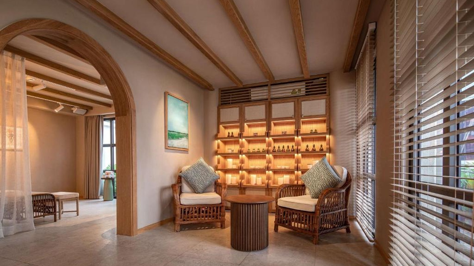 Lounge spa dùng trần gỗ, cửa vòm và ghế mây để tạo nhịp chuyển tiếp tĩnh lặng.