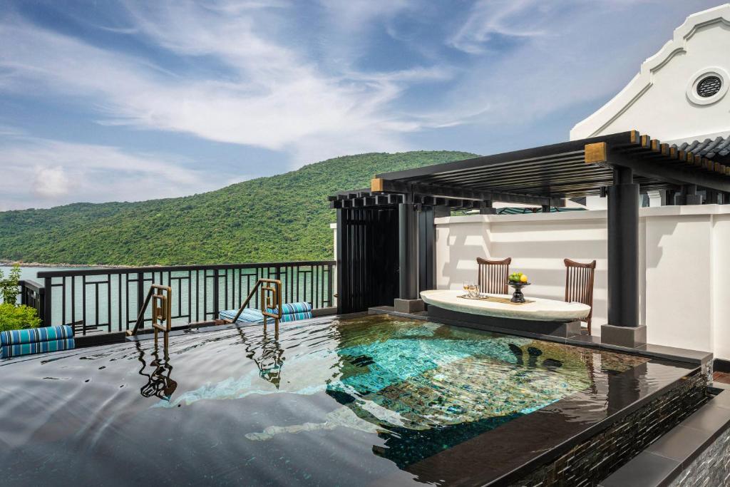 Hồ bơi vô cực riêng tư kết nối pergola, ghế ngâm và đường chân trời của vịnh.