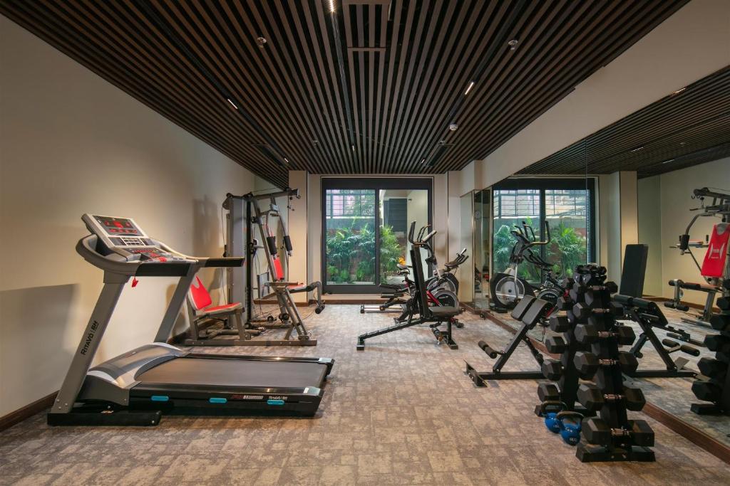 Phòng gym khách sạn 5 sao với máy chạy bộ, xe đạp, tạ tay và gương toàn tường