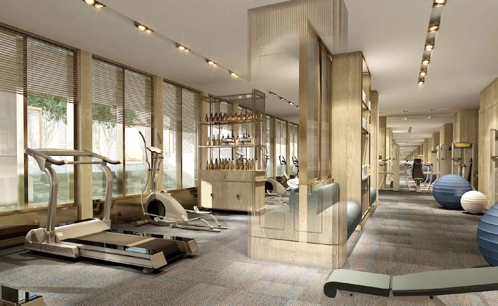 Phòng gym dài, sáng với máy cardio, thiết bị sức mạnh và bóng tập đa dạng.