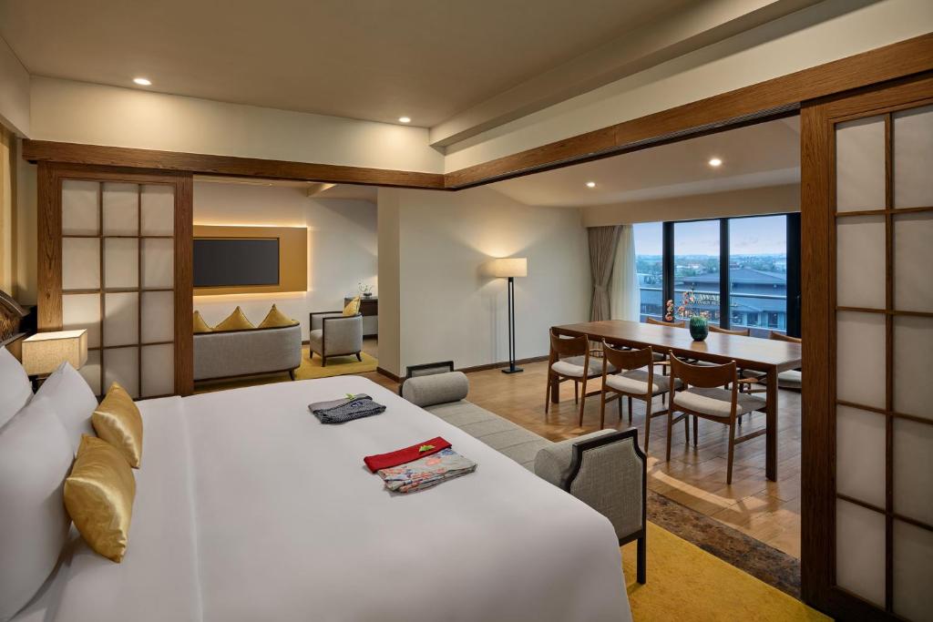 Giường trắng, khung gỗ và cửa trượt tạo một phòng nghỉ cân bằng giữa tinh thần ryokan và tiện nghi hiện đại.
