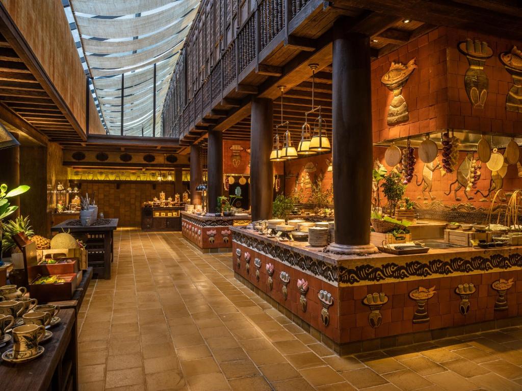 Quầy buffet, cột gỗ, gốm và họa tiết trang trí kể câu chuyện ẩm thực Indochine.