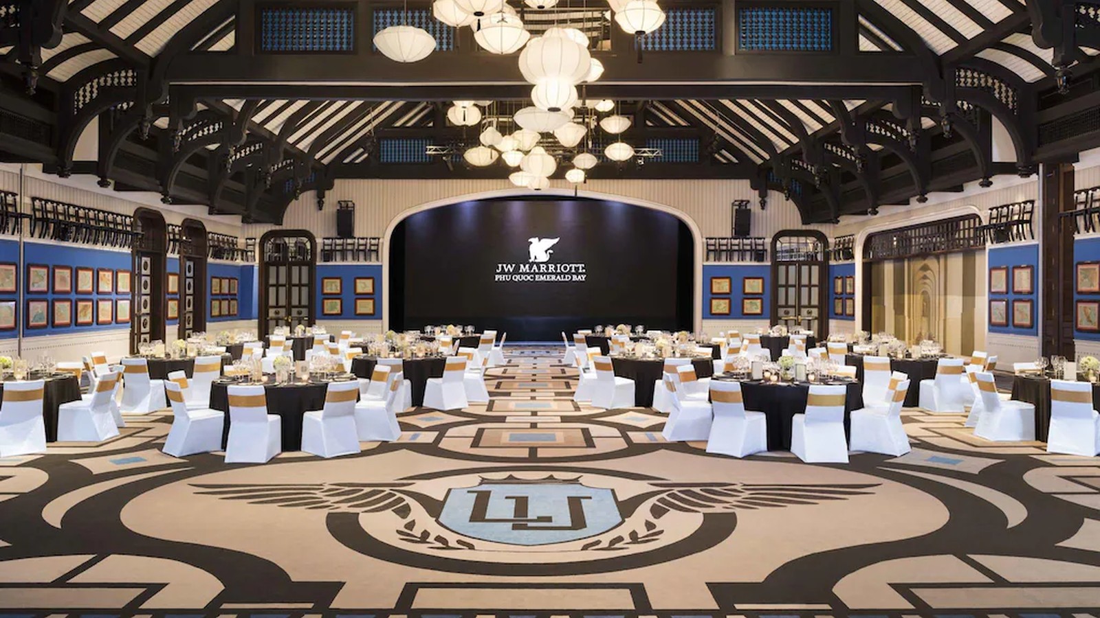 Ballroom kết hợp mái cao, đèn lồng, thảm lớn và sân khấu cho sự kiện quy mô lớn.