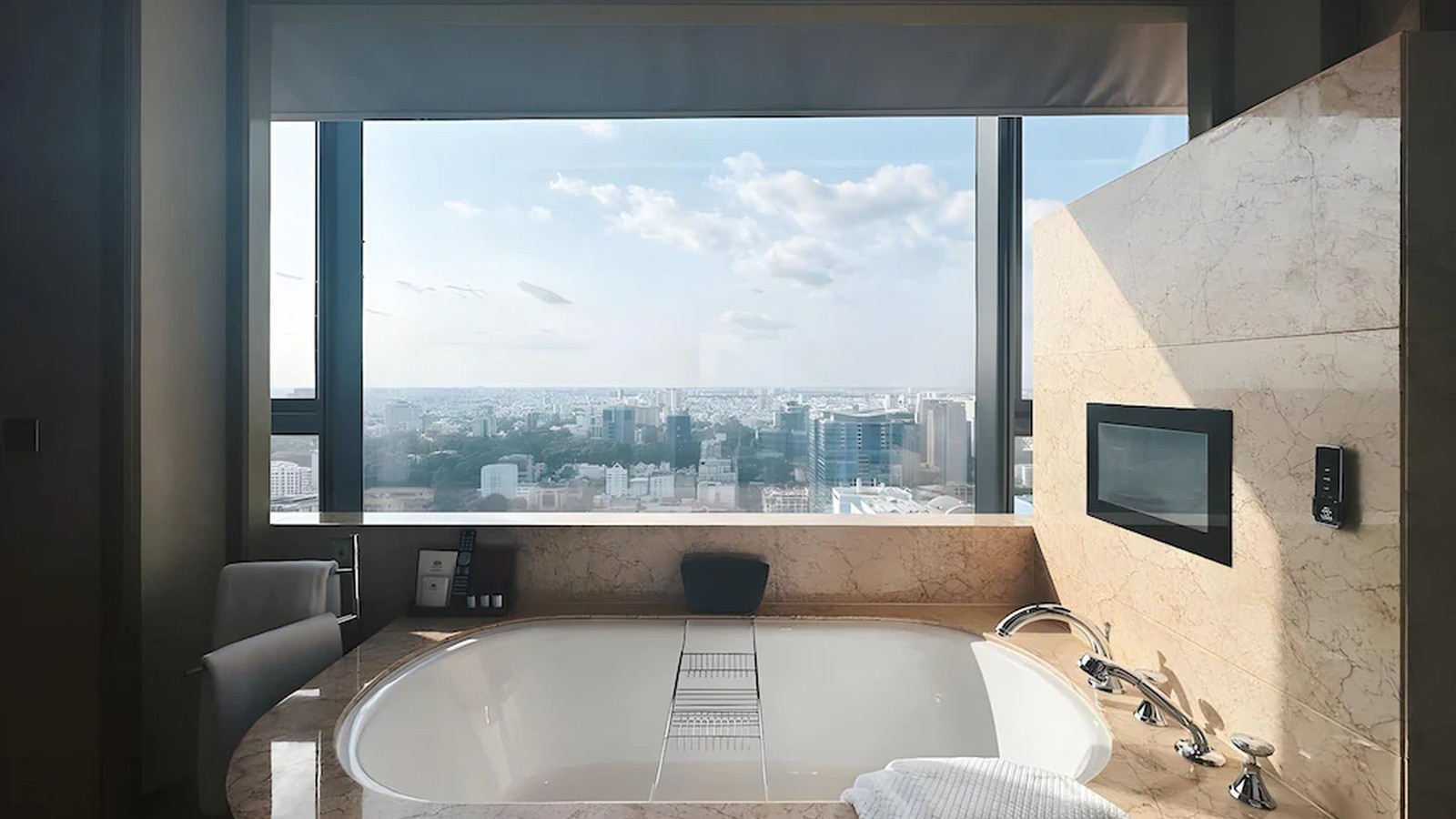 Bồn tắm bao quanh bởi đá, kết nối trực tiếp với khung cửa nhìn ra cảnh quan.