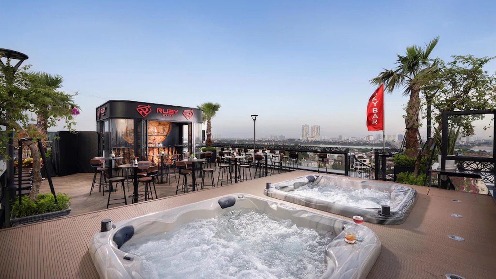 Jacuzzi sân thượng kết hợp bể sục, quầy bar, cây xanh và tầm nhìn đô thị trong một tiện ích thư giãn khác biệt.
